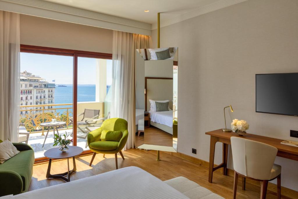 a living room with a bed and a room with a view at Electra Palace Thessaloniki in Thessaloniki