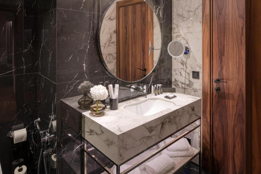 a bathroom with a marble sink and a mirror at Electra Palace Thessaloniki in Thessaloniki