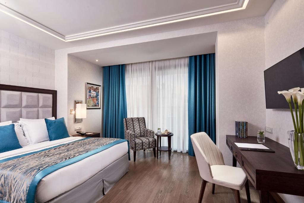 a hotel room with a bed and a desk at Electra Metropolis in Athens