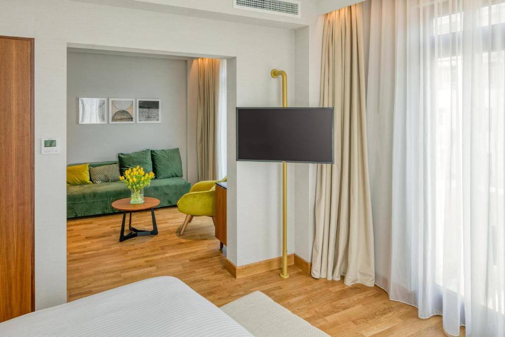 a living room with a green couch and a table at Electra Palace Thessaloniki in Thessaloniki