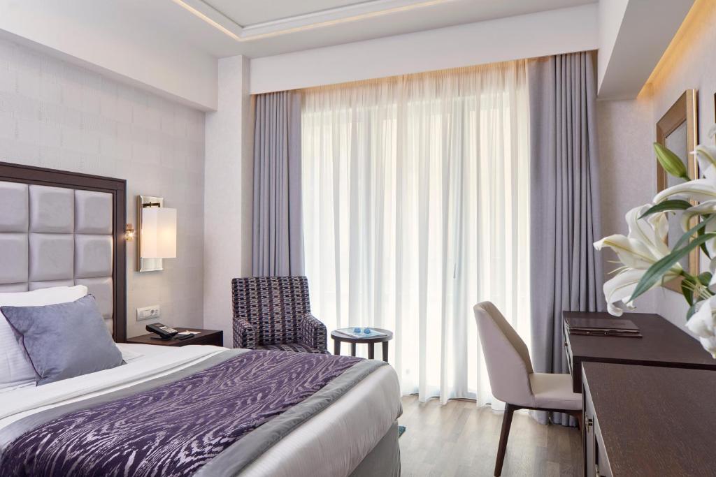 a hotel room with a bed and a desk and a bedroom at Electra Metropolis in Athens