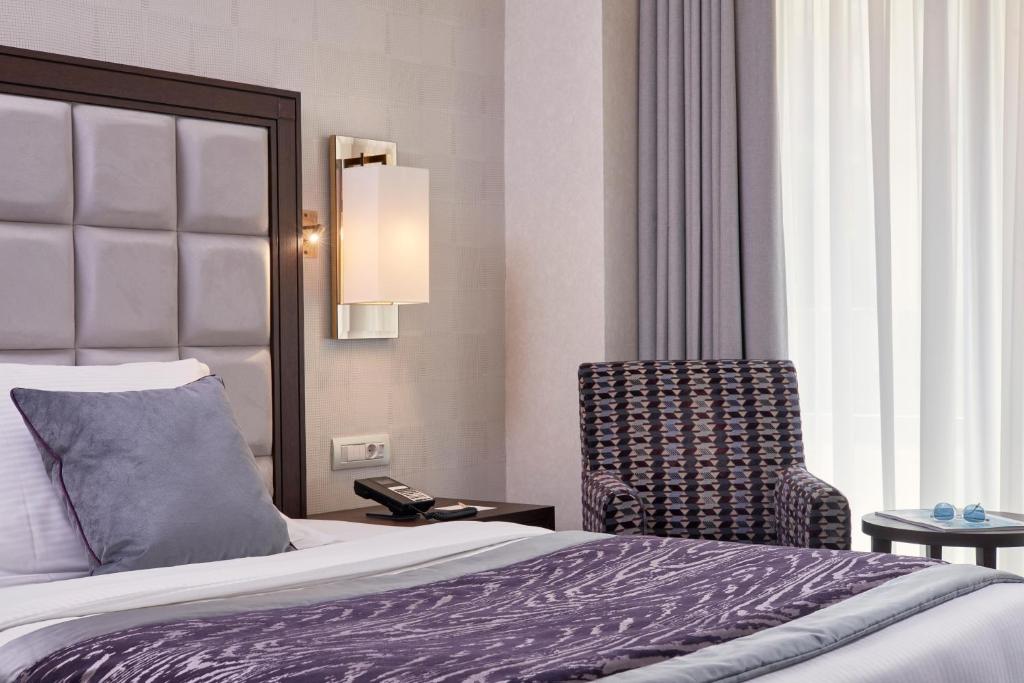 a hotel room with a bed and a chair at Electra Metropolis in Athens