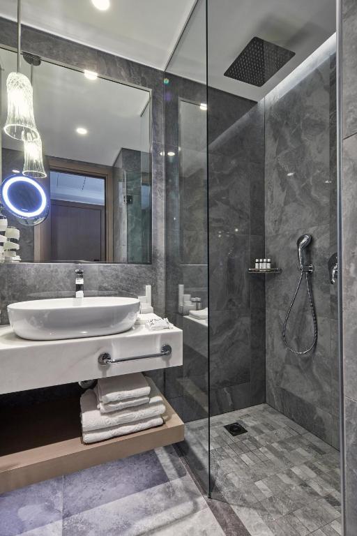 a bathroom with a sink and a shower at Electra Metropolis in Athens