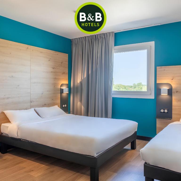 une chambre avec deux lits et une fenêtre dans l'établissement B&B HOTEL Saint-Martin-de-Crau Alpilles Camargue, à Saint-Martin-de-Crau
