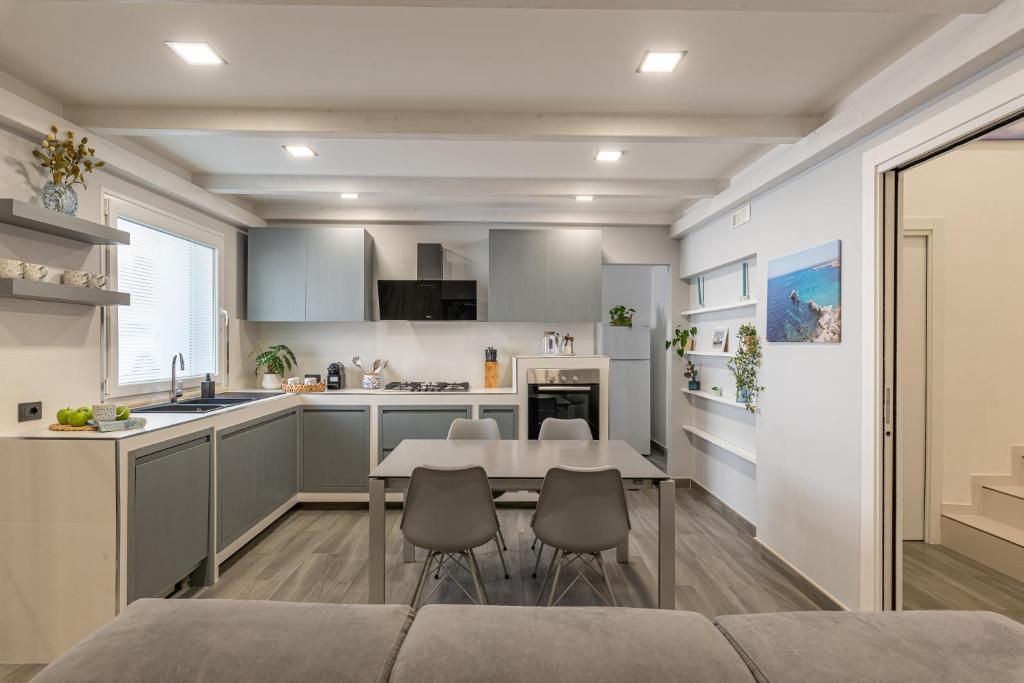 Una cocina y un comedor con mesa y sillas. en La Dolce Vista - Magaggiari, en Terrasini