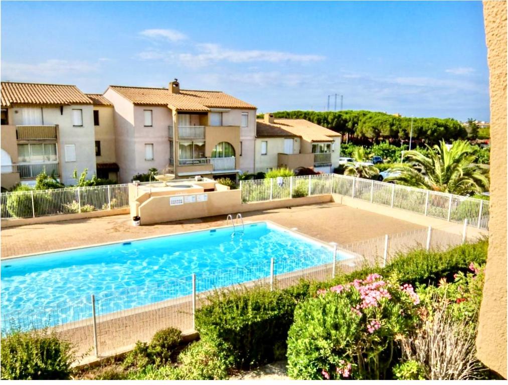 une grande piscine devant une maison dans l'établissement T2 cap d'agde, au Cap d'Agde