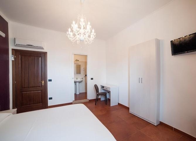 a bedroom with a bed and a desk and a chandelier at Metropoli's in Taurianova