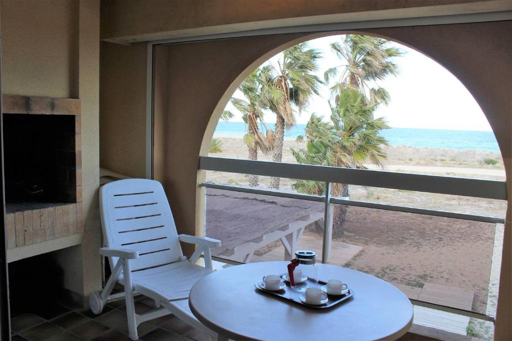 Cette chambre dispose d'une table et offre une vue sur la plage. dans l'établissement Zénitude pour ce bien en front de mer avec parking privatif - 4LAG502, à Saint Cyprien Plage