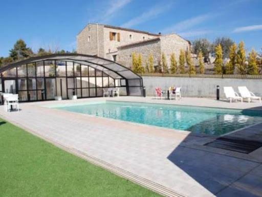 une grande piscine devant un immeuble dans l'établissement Chambres d'hôtes à Pêtre, à Entrevennes