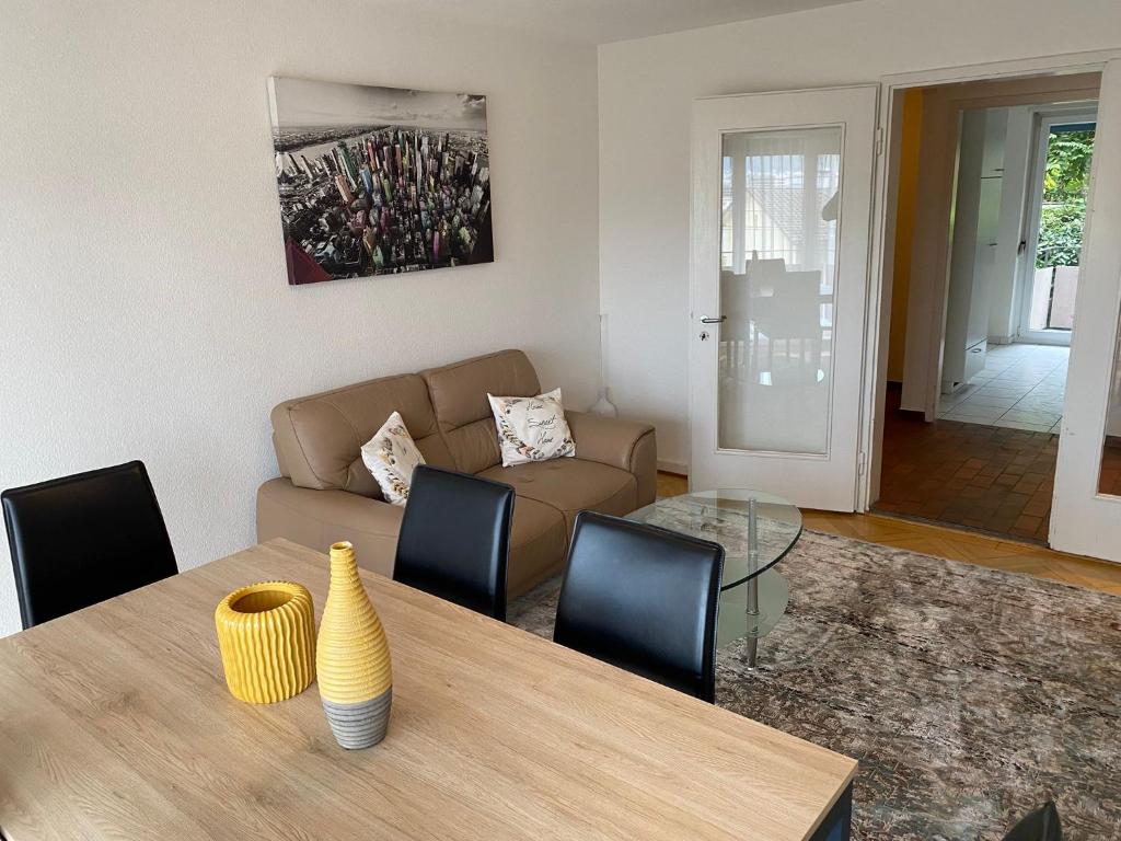 una sala de estar con una mesa y un sofá en 2BR near city center - Vineyard 21, en Zúrich