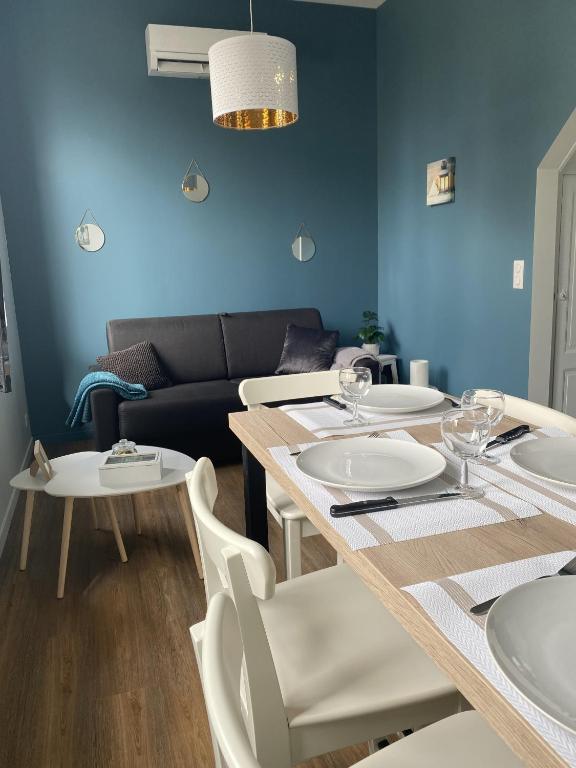une salle à manger avec une table, des chaises et un canapé dans l'établissement Marianne 4, à Bergerac