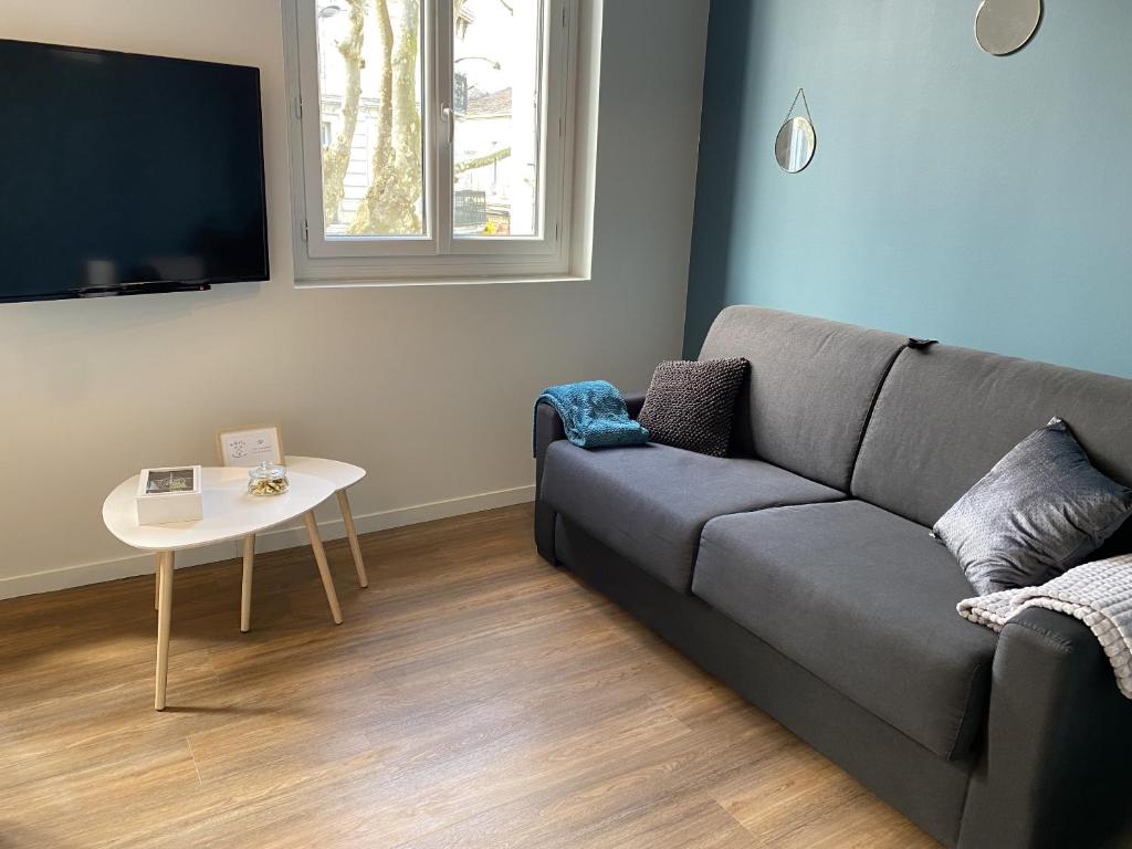 una sala de estar con un sofá y una mesa en Marianne 4, en Bergerac