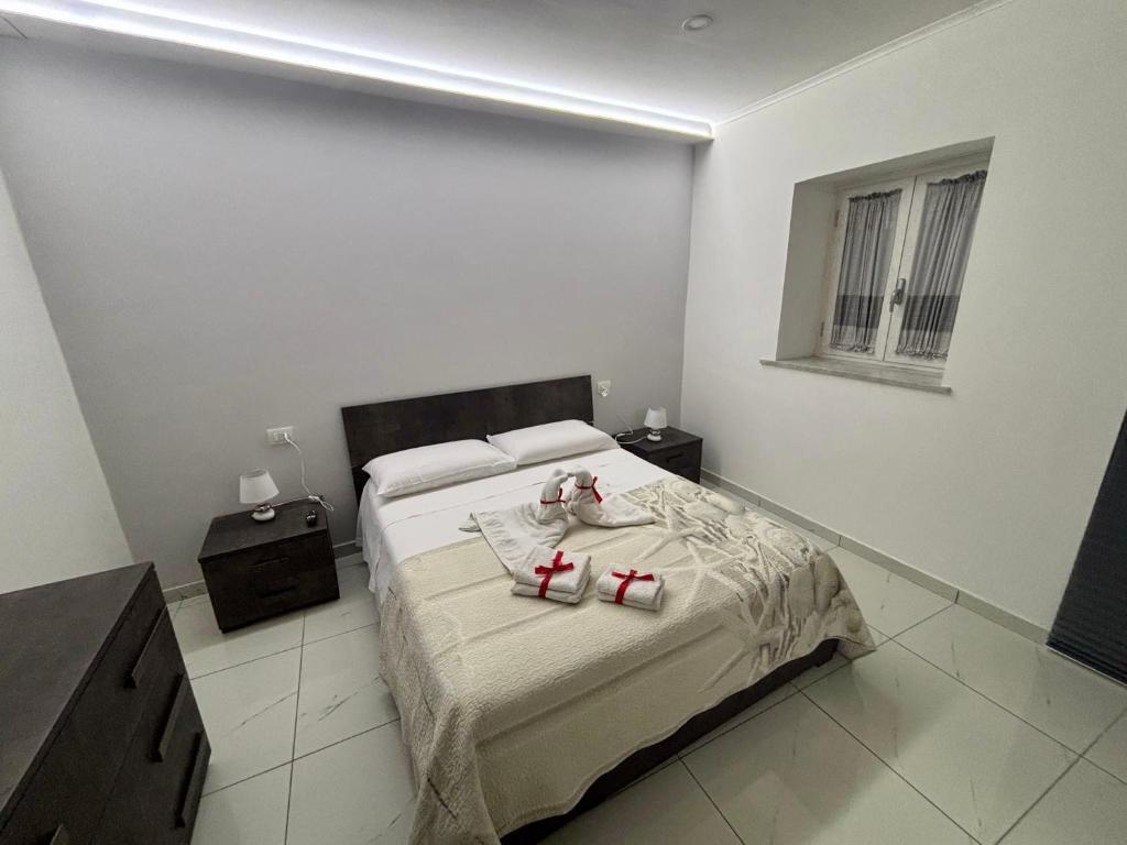 sypialnia z łóżkiem z dwoma czerwonymi butami w obiekcie B&B Aria di Sole w mieście Neapol