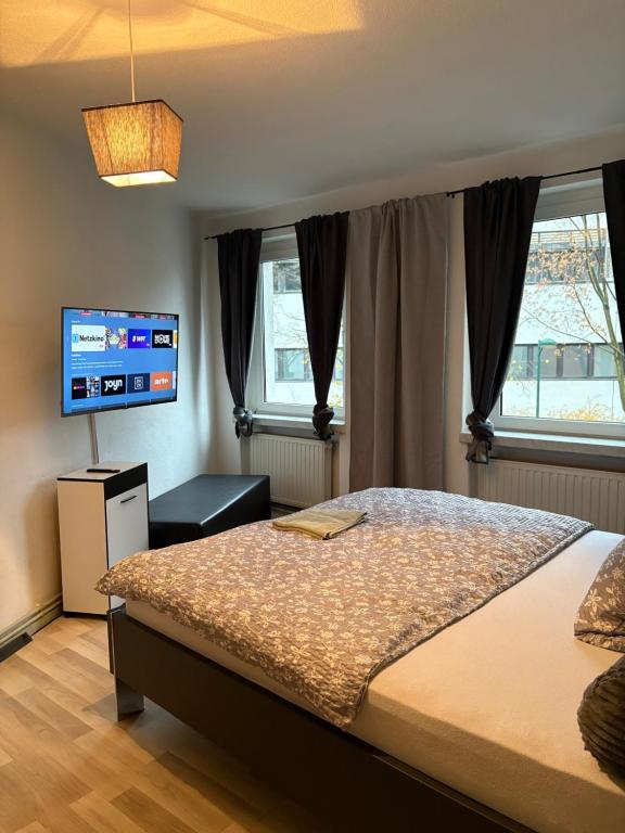 a bedroom with a bed and a flat screen tv at Pension Winter Untergeschoss in Senftenberg