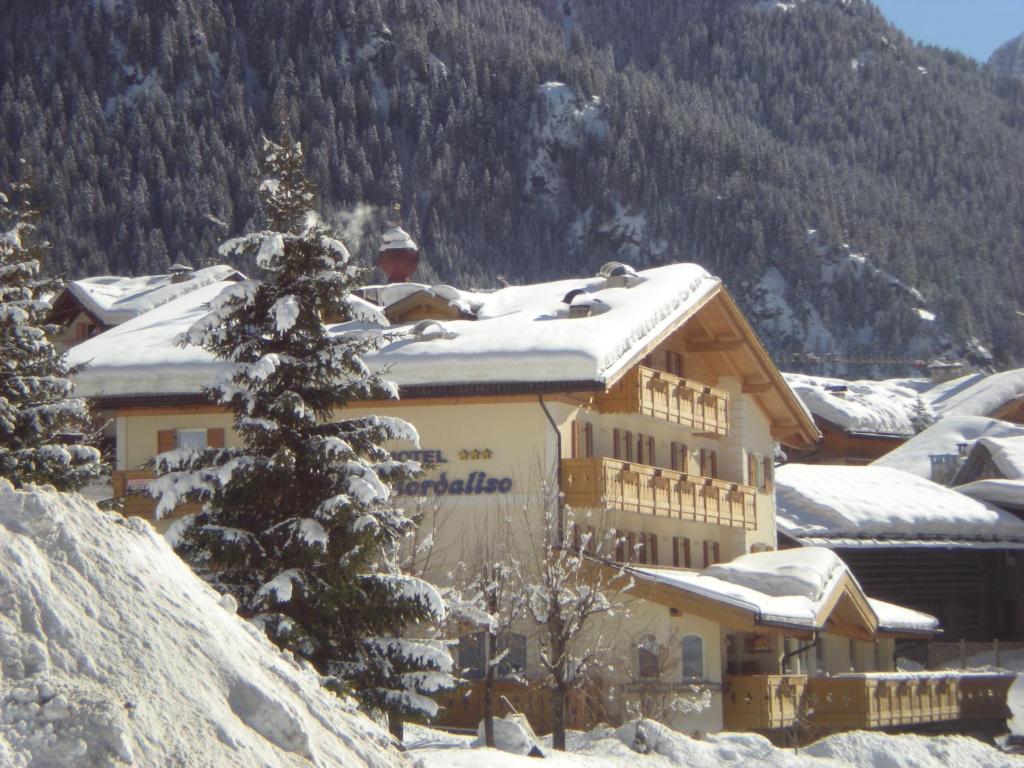 un gran edificio con nieve en la cima de una montaña en Albergo Fiordaliso, en Canazei