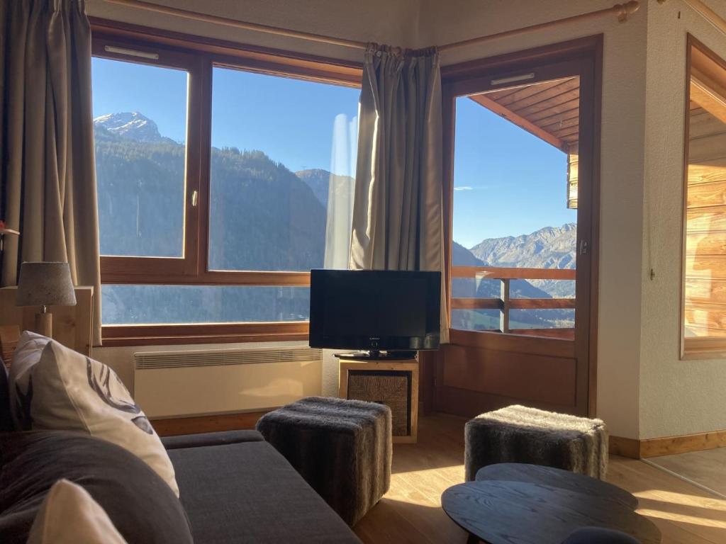 un salon avec une télévision et une grande fenêtre dans l'établissement Appartement cosy à Châtel : 5 pers, balcon, parking, WIFI - FR-1-676-32, à Châtel