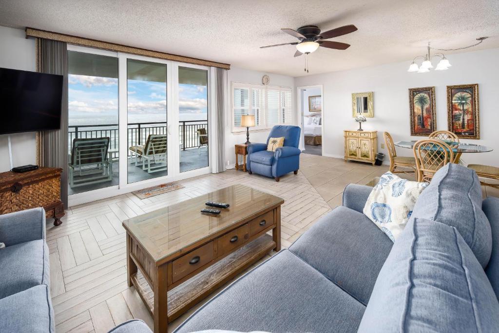 ein Wohnzimmer mit einem blauen Sofa und einem Fernseher in der Unterkunft Nautilus 1702 Gulf Front Large 2 Bedroom Penthouse 7th Floor in Fort Walton Beach