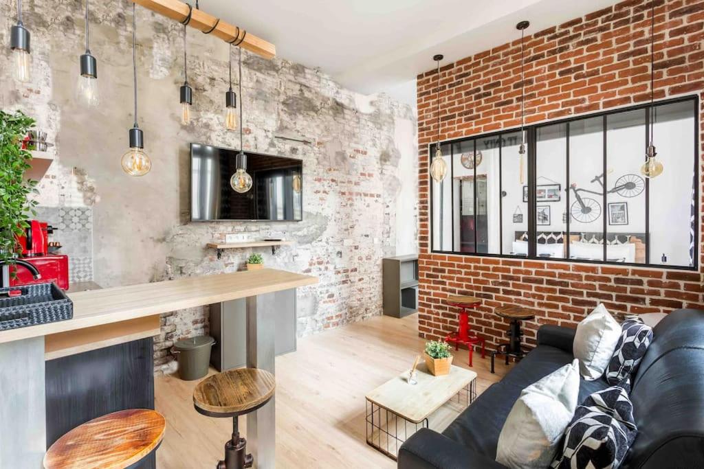 un salon avec un canapé et un mur de briques dans l'établissement M2- Modern Loft in Le Marais, Bright and Comfortable, à Paris
