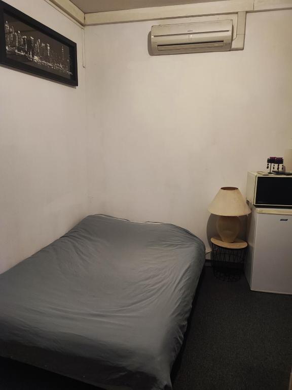 - une petite chambre avec un lit et un four micro-ondes dans l'établissement Chambre st Vallier, à Saint-Vallier