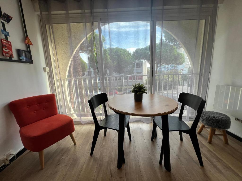 une salle à manger avec une table et des chaises et une fenêtre dans l'établissement Studio Factory Loft, à La Grande Motte