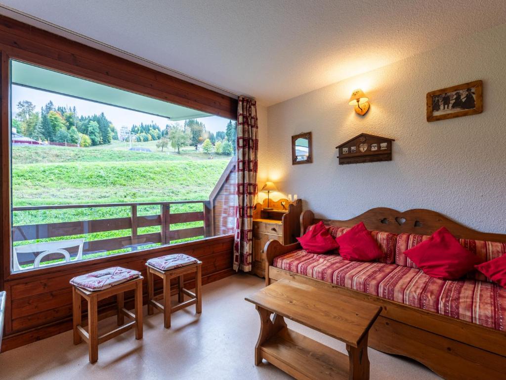Un dormitorio con una cama y una ventana grande. en Les Eterlous - 8 - Appt Montagne 4-6 pers, en Morillon
