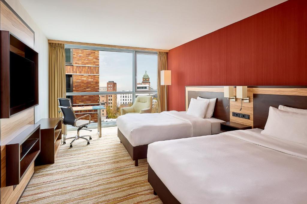ein Hotelzimmer mit 2 Betten und einem Flachbild-TV in der Unterkunft Courtyard by Marriott Duesseldorf Hafen in Düsseldorf