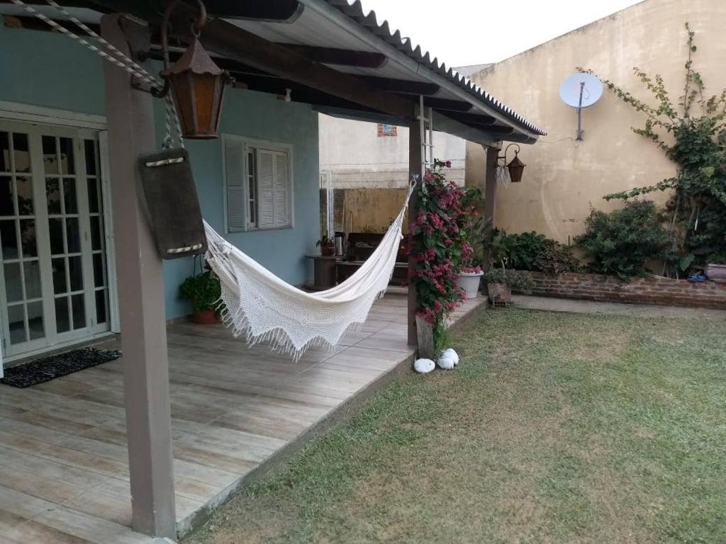 a hammock on the porch of a house at Casa verão 2025 in Tramandaí