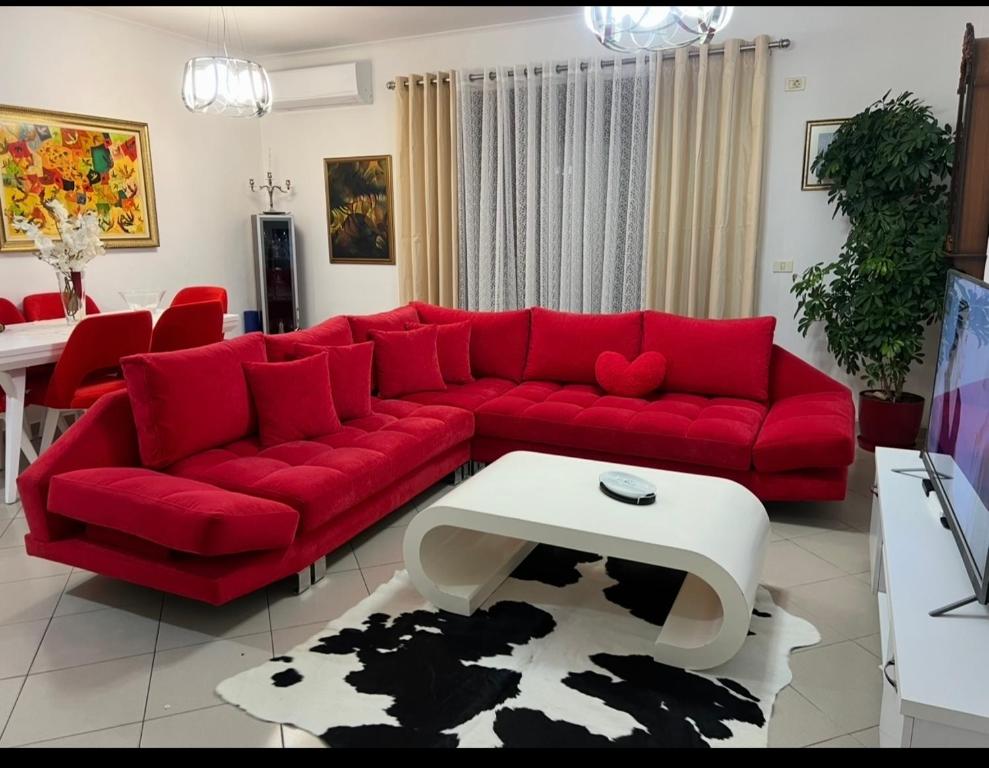 a living room with a red couch and a table at Rita Apartment in Tirana centre in Tirana