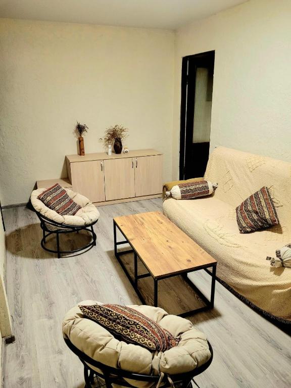 una sala de estar con un sofá, una mesa y sillas en District 24, en Tiflis