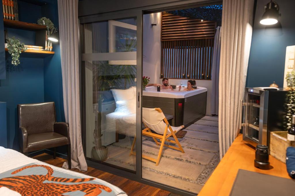 a bedroom with a bathroom with a sink and a desk at Yanna Lodge, gîte classé 4 étoiles avec Spa couvert entièrement in Arrest