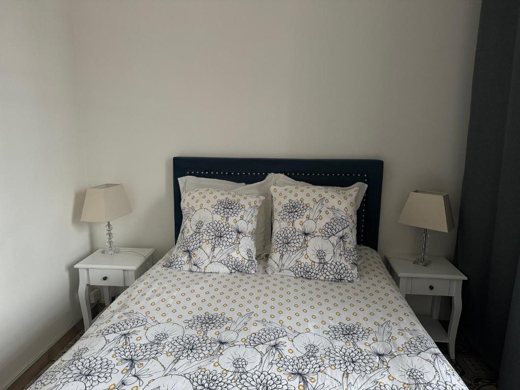 a bedroom with a bed with pillows and two lamps at Studio Le Mansart au pied du Château Insead in Fontainebleau