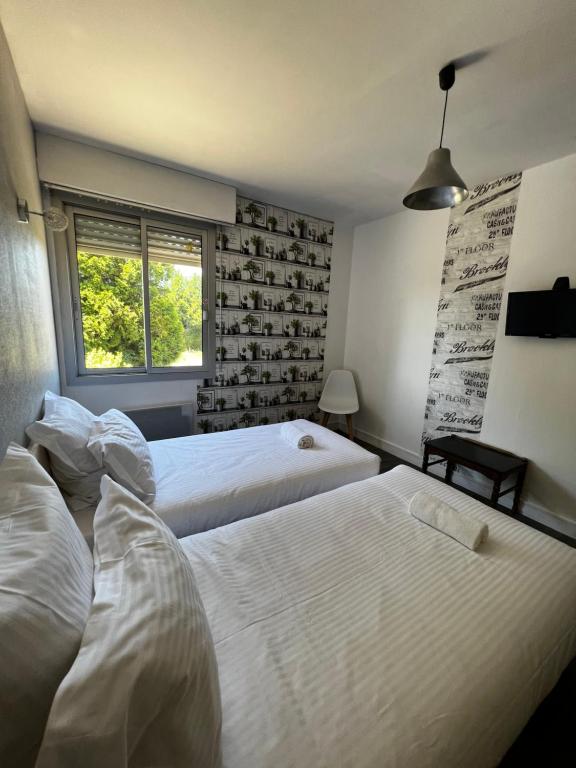 Postel nebo postele na pokoji v ubytování Contact Hotel Les Montois