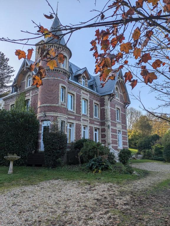 une grande maison en briques avec une tour en haut dans l'établissement Chambre d'hôte - petit château à la campagne, à Saint-Aubin-Epinay