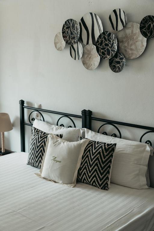 a bed with pillows and hats on the wall at Astrio Suites in Livadi