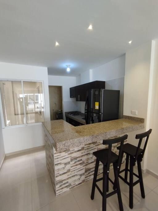 a kitchen with two bar stools and a counter top at Edificio Verona 57 - Apartamento en Piedecuesta in Piedecuesta