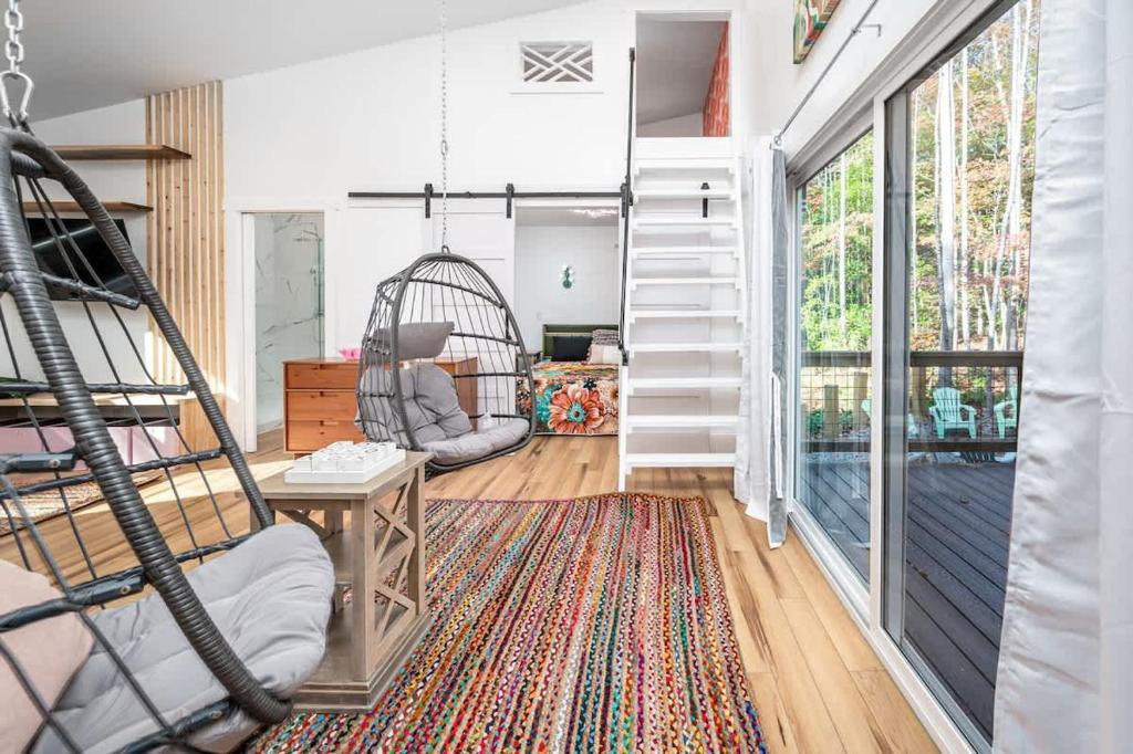 a living room with a staircase and a swing at Full Bloom Tree House in Pittsboro