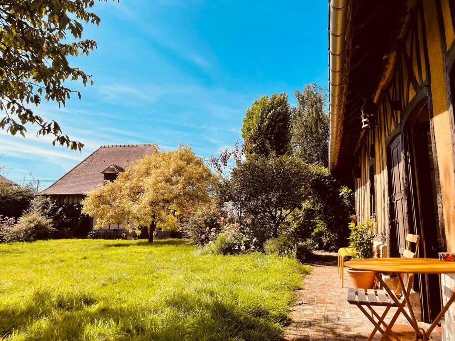 une table sur le côté d'un bâtiment avec une cour dans l'établissement Maison Hestia - Collection Idylliq, à Épégard
