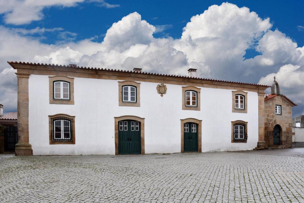 um grande edifcio branco com duas portas em Casa da Fidalga em Outeiro de Gatos