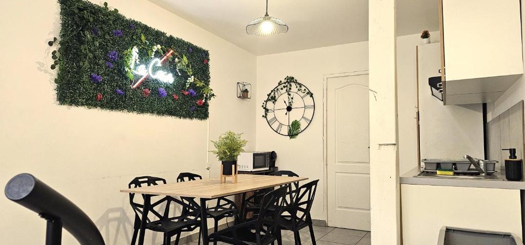 une cuisine avec une table, des chaises et une horloge murale dans l'établissement Appartement mi-troglodyte 4 a 6 personnes de 75 m, à Orléans