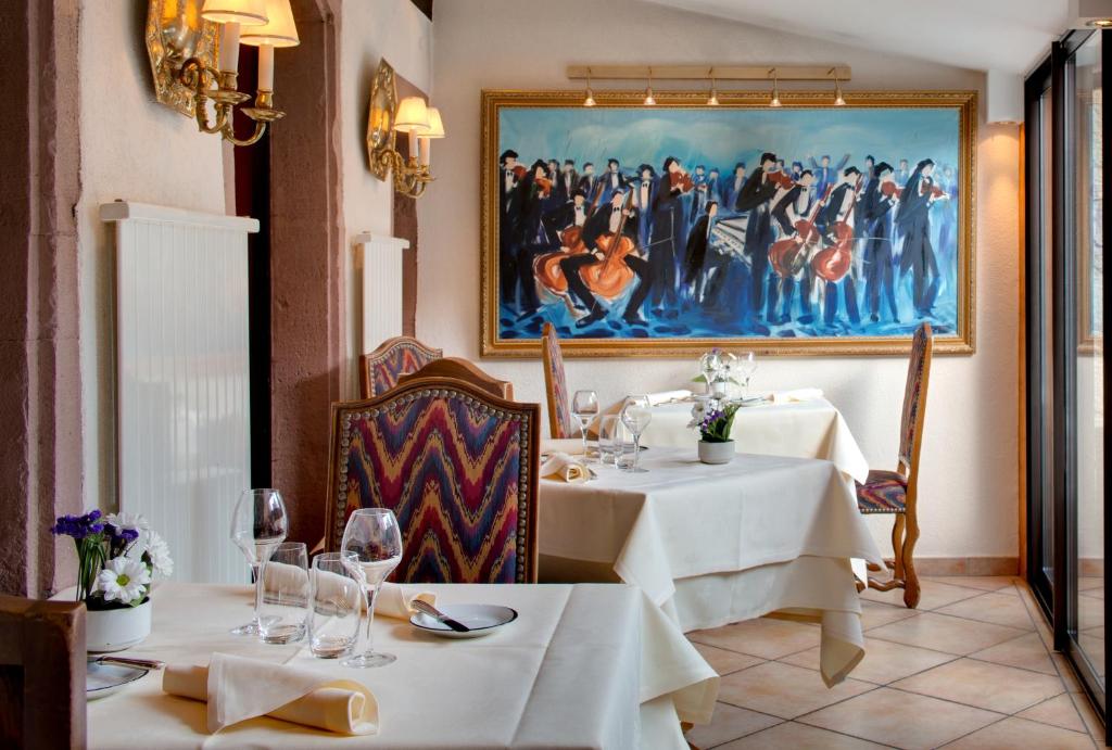 a restaurant with two tables and a painting on the wall at Hotel Restaurant Le Maréchal - Teritoria in Colmar