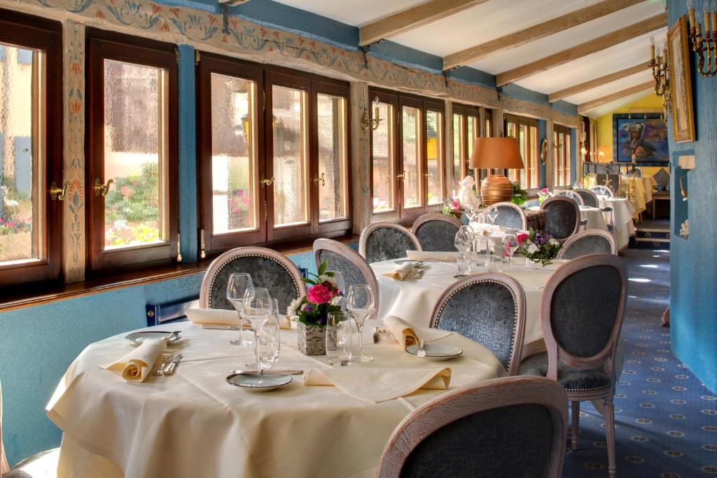 a row of tables and chairs in a restaurant at Hotel Restaurant Le Maréchal - Teritoria in Colmar