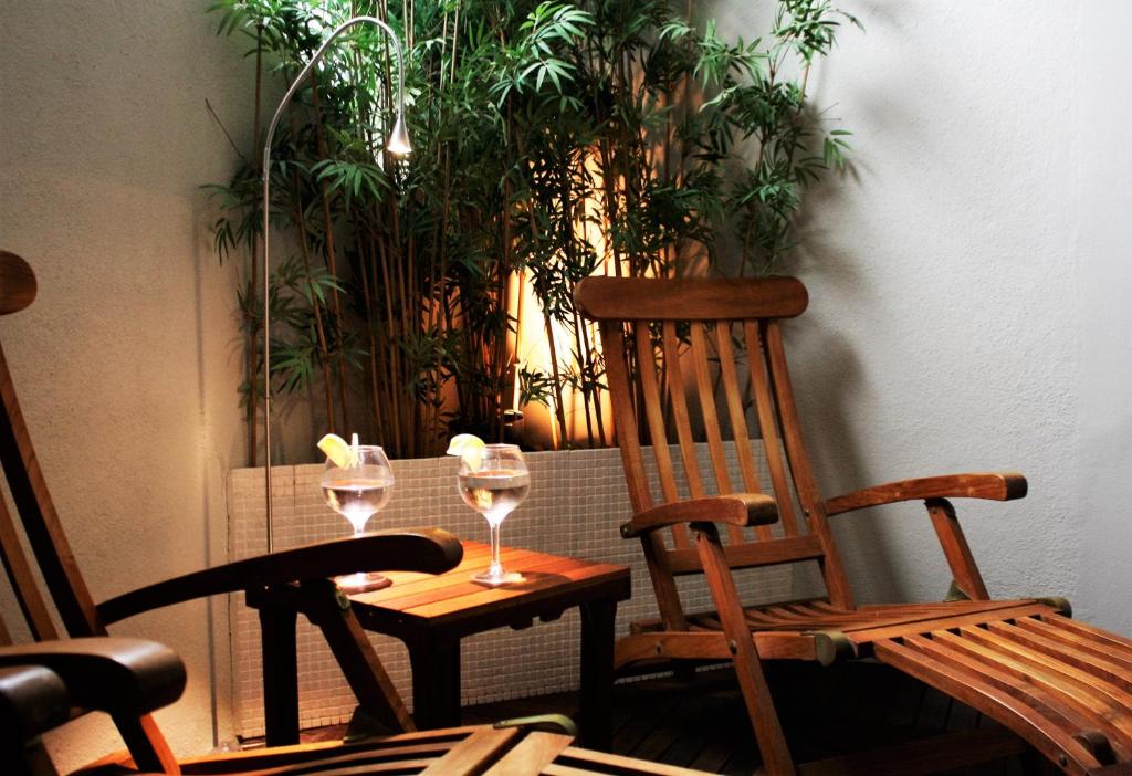 a table with two glasses of wine and a chair at miKasa Agua Amarga & SPA in Agua Amarga