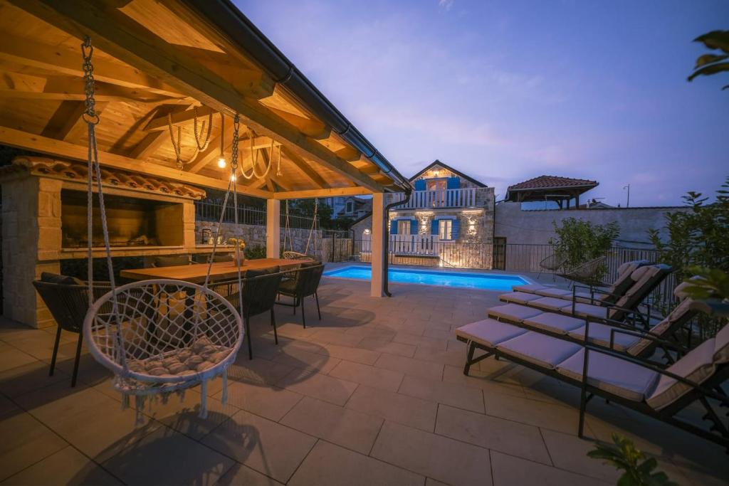a patio with a bar and a swimming pool at Villa Dalmatina Charming stone house with pool, 40 m from see in Tribunj