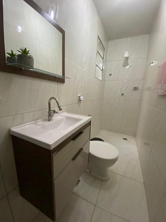 Un baño blanco con lavabo e inodoro. en Solange, en Vitória da Conquista