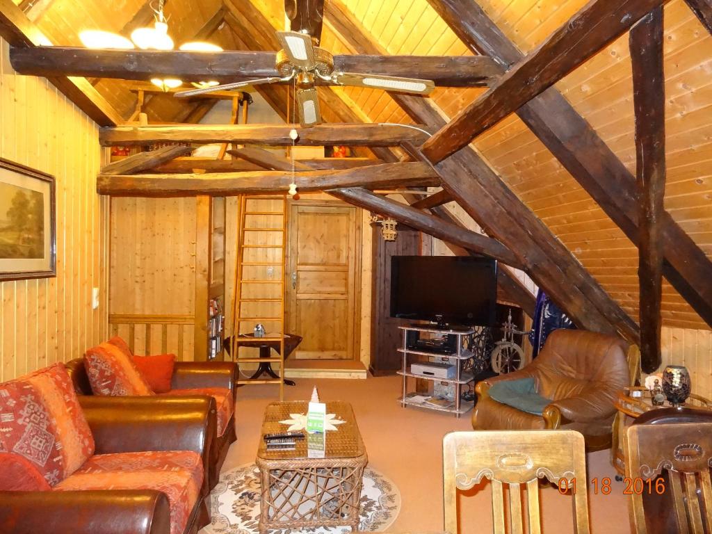 un soggiorno con divani in pelle e TV di Ferienwohnungen im Fachwerkhaus a Quedlinburg