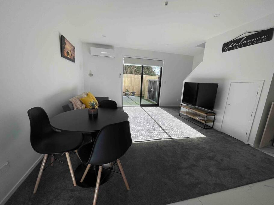 a living room with a table and a tv at Coastal Sanctuary in Christchurch