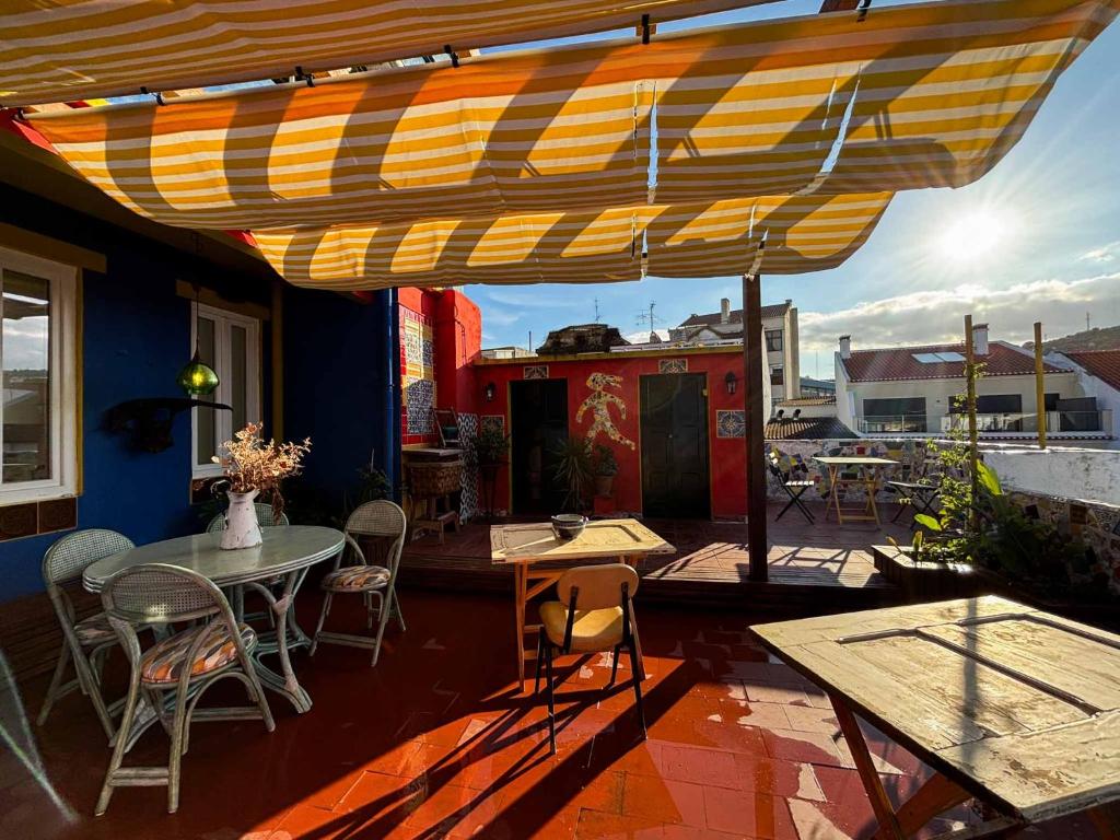a patio with a table and chairs under an umbrella at Soul - Coliving in Vila Franca de Xira