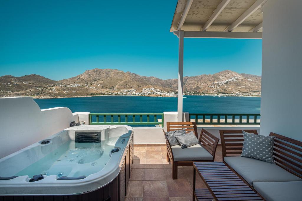 a hot tub on a balcony with a view of the ocean at Astrio Suites in Livadi