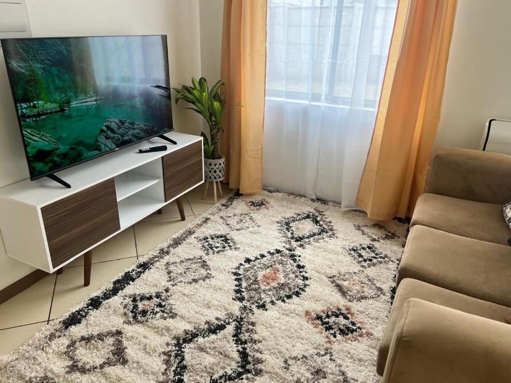 a living room with a tv and a couch at Cómoda Casa 4 DORMITORIOS 2 BAÑOS sector Oriente in Talca
