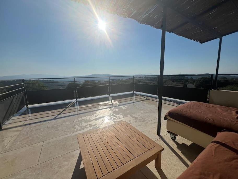 - un balcon avec un lit et une table sur le toit dans l'établissement L'appart du mas du Zébu Bleu, à Vernègues